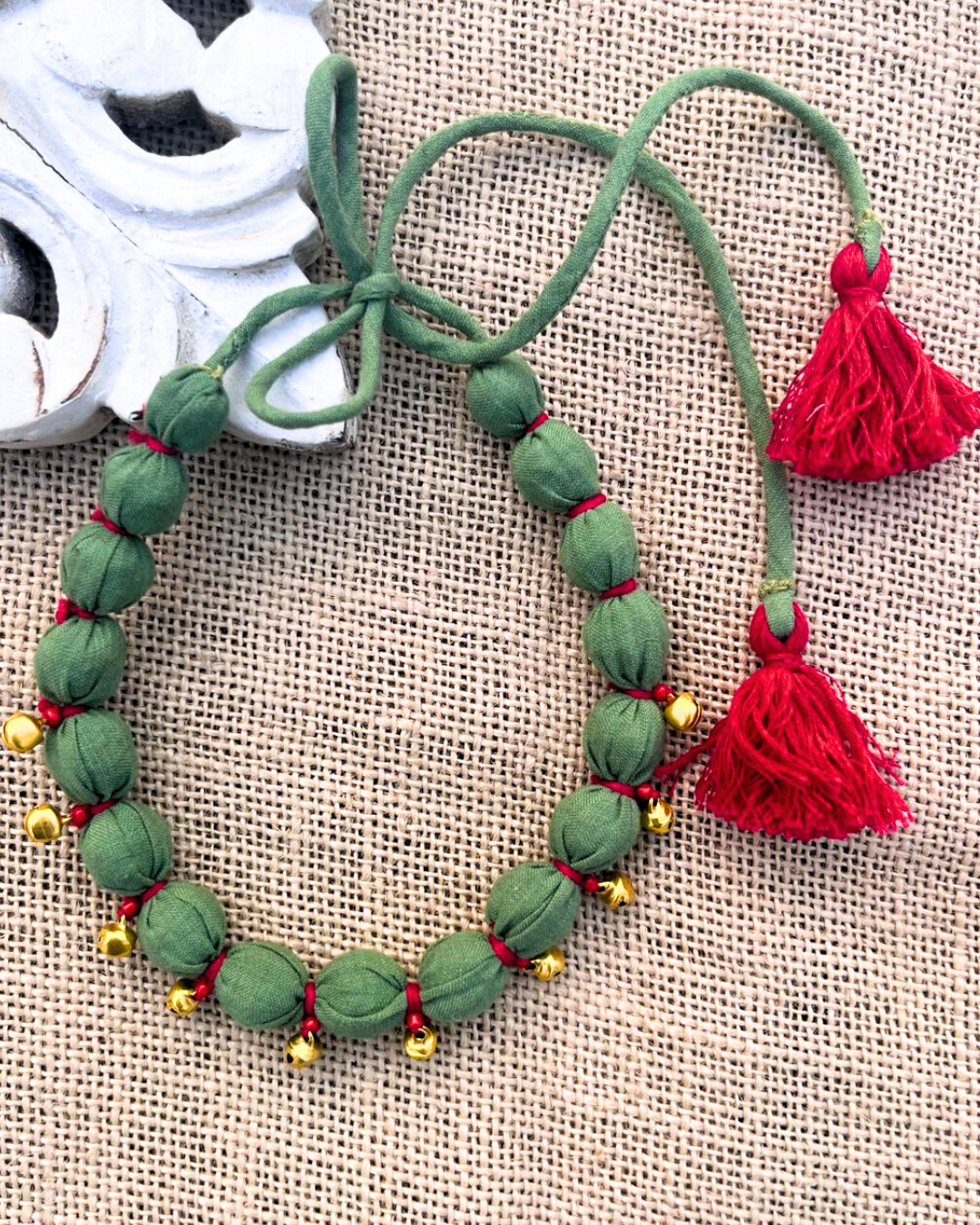 Green beaded necklace with red tassels 