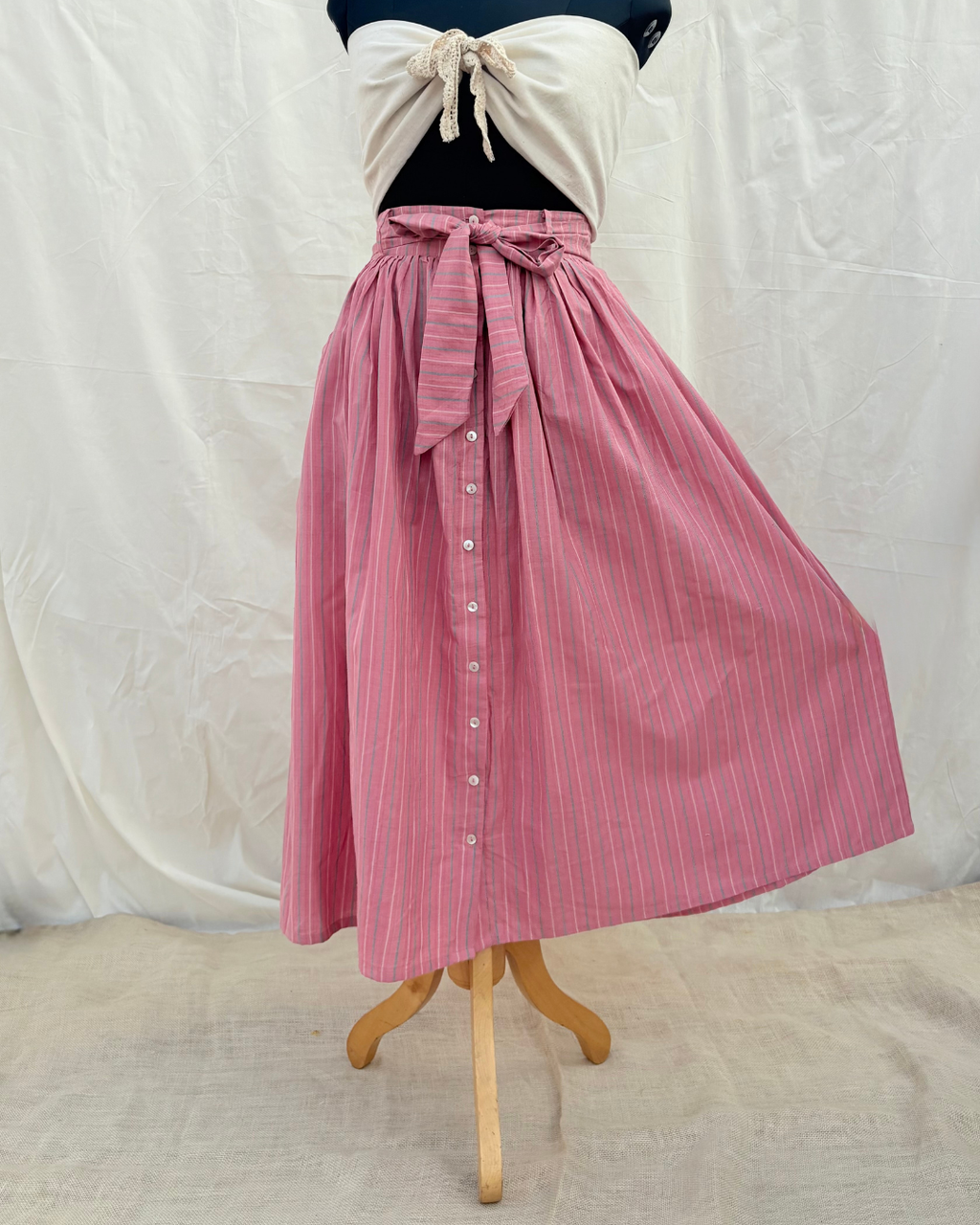 Pink striped skirt on a mannequin against a white background