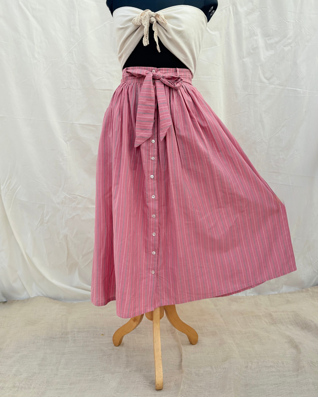 Pink striped skirt on a mannequin against a white background