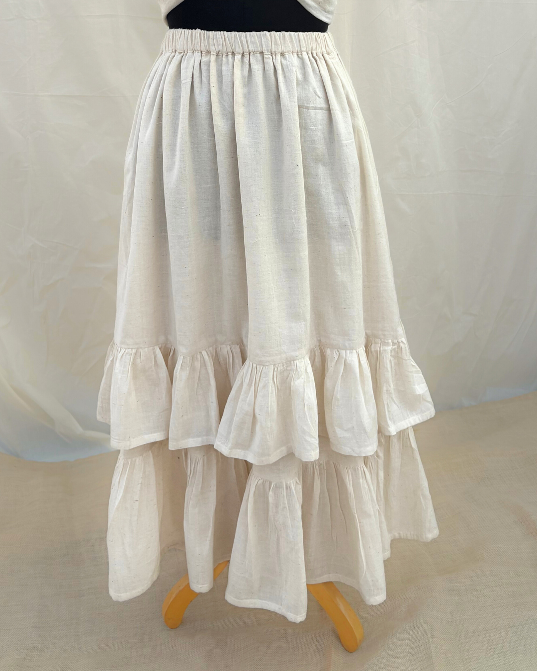 White ruffled skirt on a mannequin against a white background